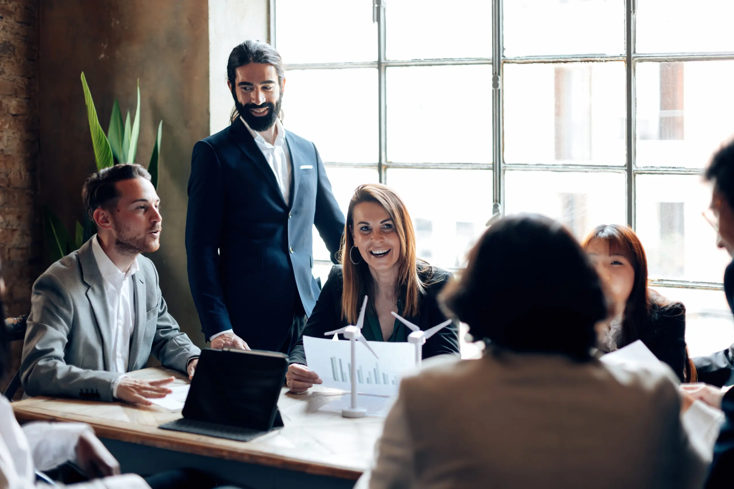 Sales operation team meeting at a table with computers and personnel at each chair